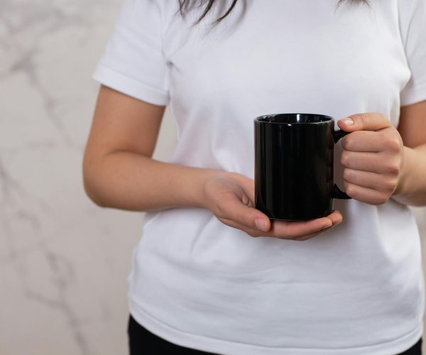 Людина тримає теплу чашку як символ спокійного щоденного ритму.